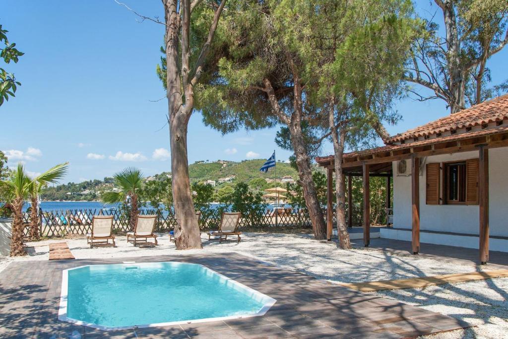 a swimming pool with chairs and a house at Amouage Boutique Home in Skiathos