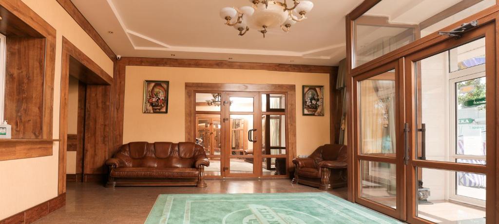 a living room with leather furniture and a chandelier at Green City Hotel in Mykolaiv