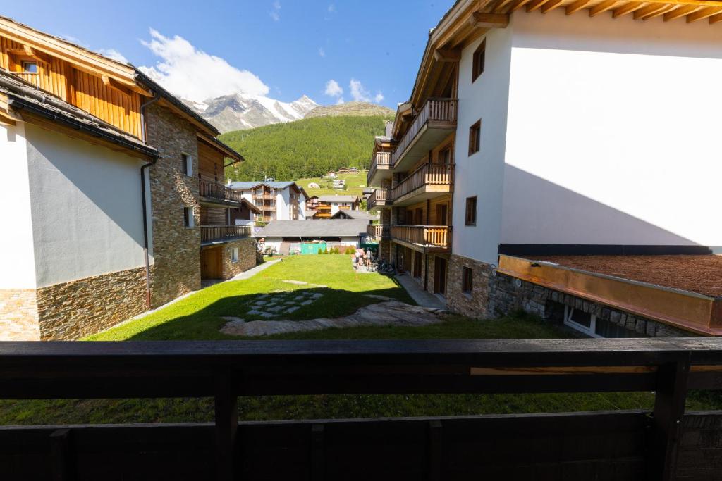 a view from the balcony of a building with a green yard at Haus Slalom in Saas-Fee