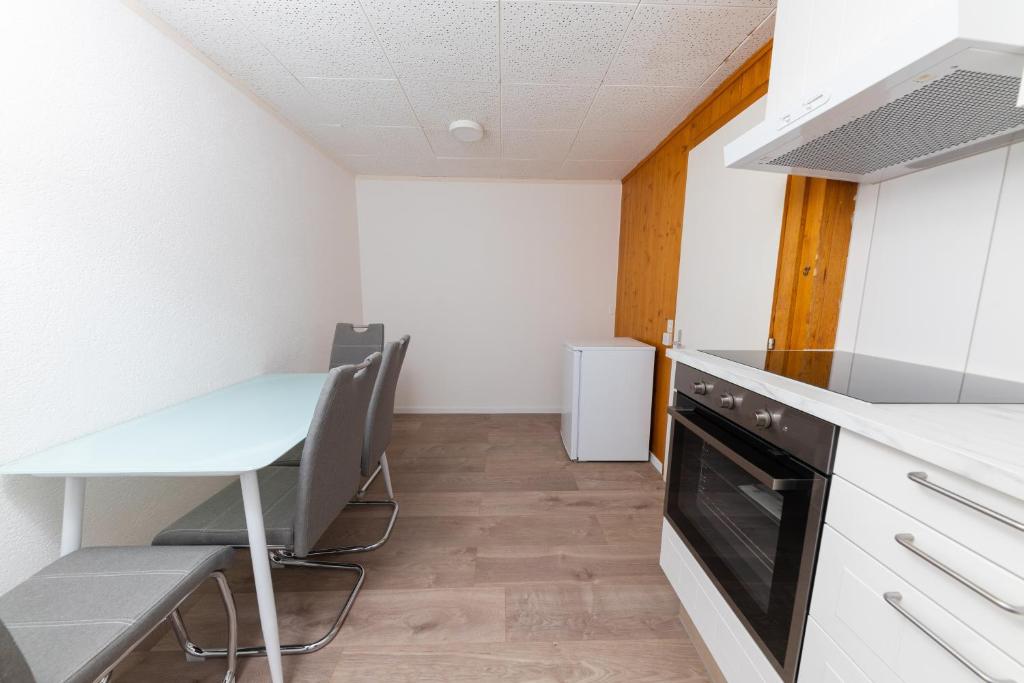 a kitchen with a desk and a table and a dishwasher at Haus Slalom in Saas-Fee