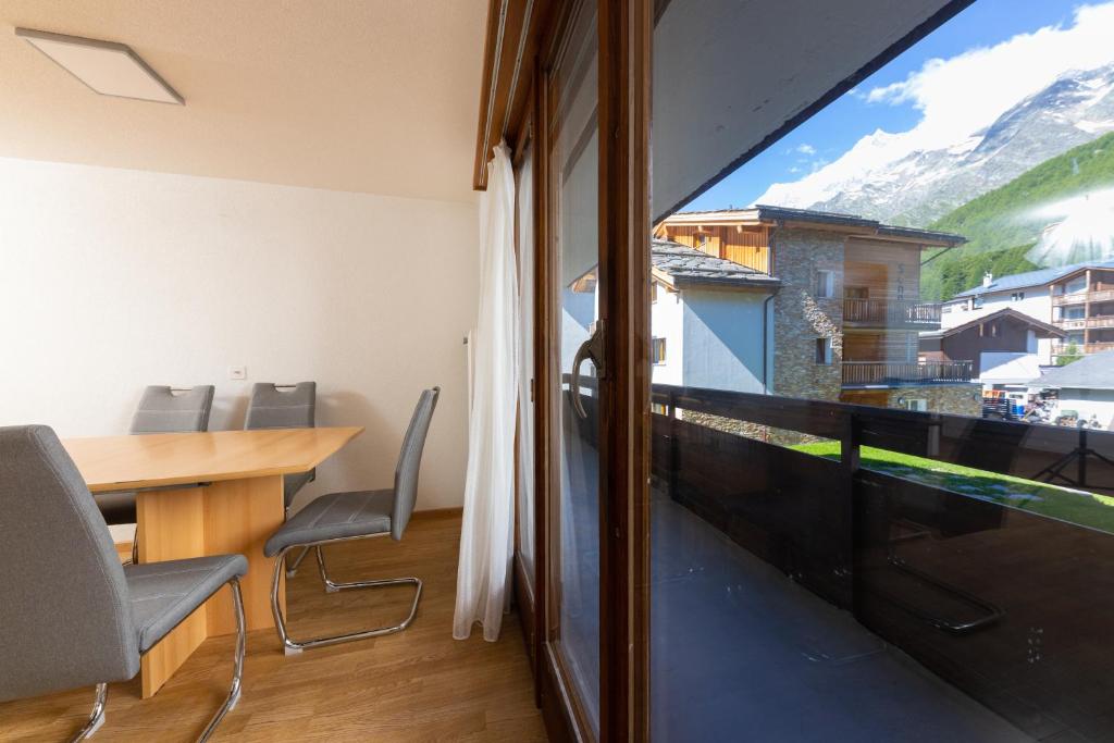 a room with a table and chairs and a window at Haus Slalom in Saas-Fee