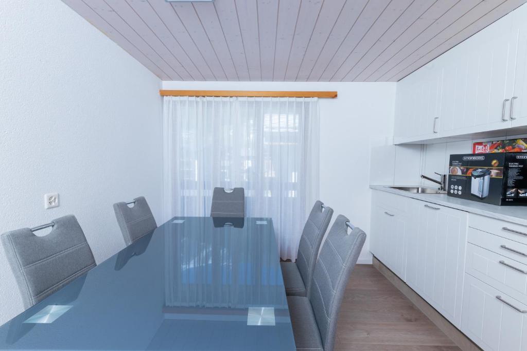 a dining room with a glass table and chairs at Haus Slalom in Saas-Fee