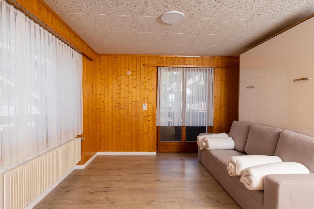 a living room with a couch and a window at Haus Slalom in Saas-Fee