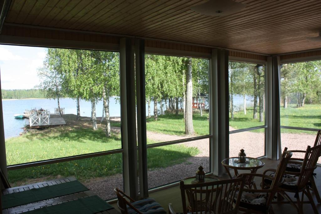 a screened in porch with a view of the water at Cottage Baydar in Jyräänkoski