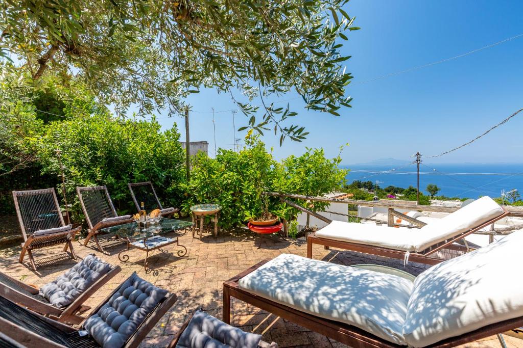 eine Terrasse mit einem Haufen Stühle und Tische in der Unterkunft Capri Suites de Charme by Napoliapartments in Anacapri