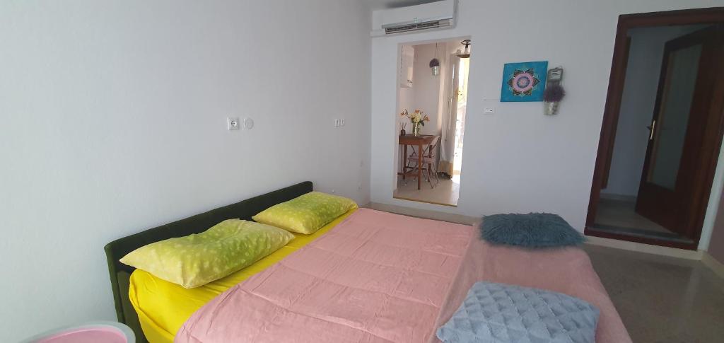 - une chambre dotée d'un lit avec des oreillers jaunes et verts dans l'établissement Apartma Jasna, à Lokev