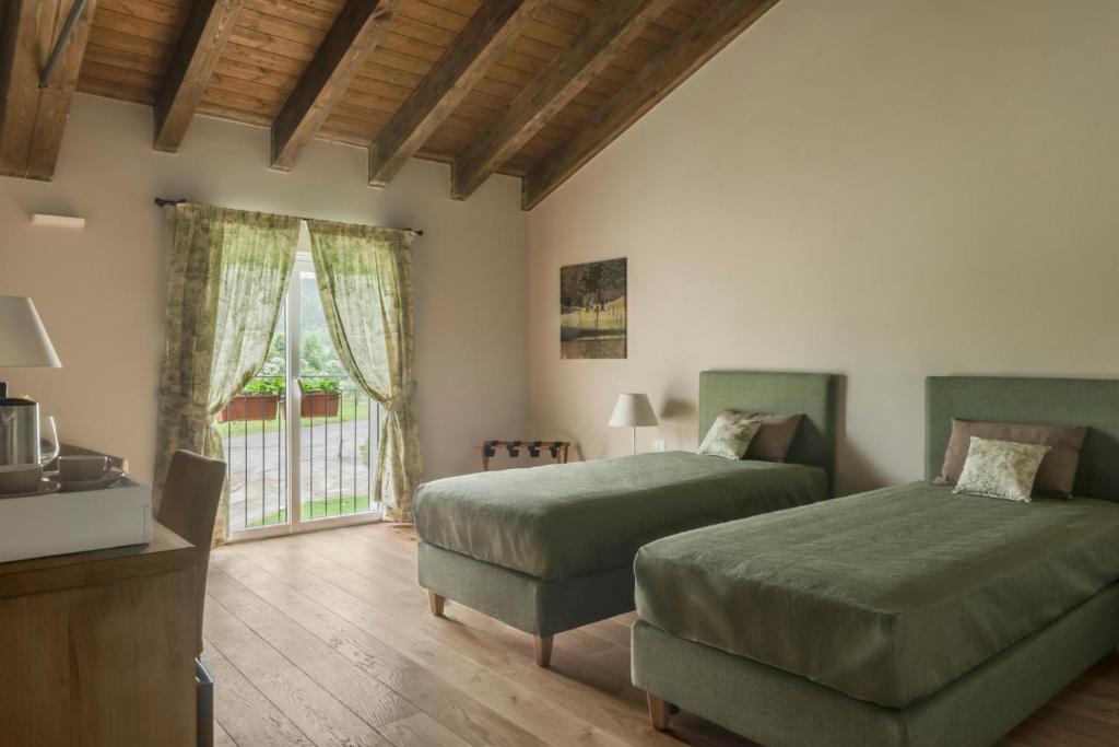 1 dormitorio con 2 camas y ventana en FORESTERIA DEL GAVI, en  Tassarolo
