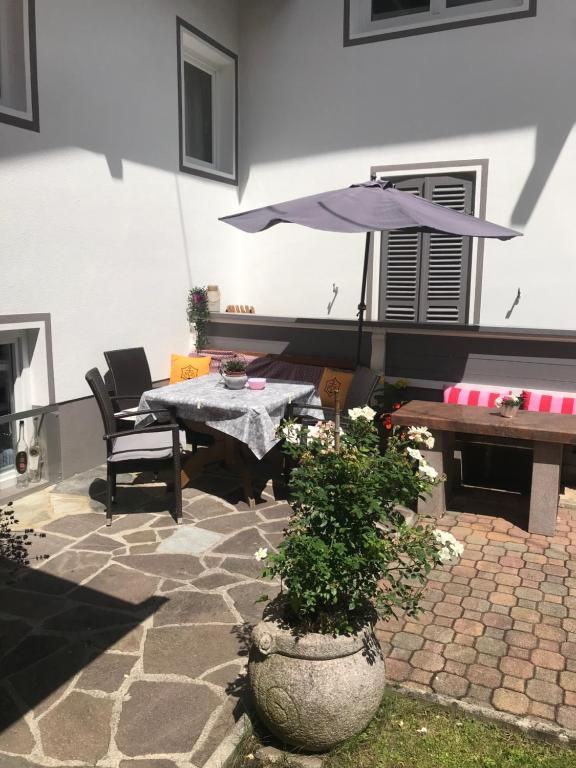 eine Terrasse mit einem Tisch, einer Bank und einem Sonnenschirm in der Unterkunft Waldhaus Lechner Steinerkogel in Mayrhofen