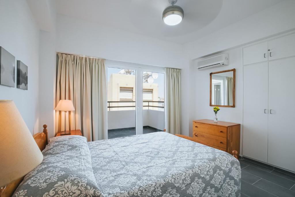 a bedroom with a bed and a dresser and a window at Lazaros Centre Apartment in Larnaca