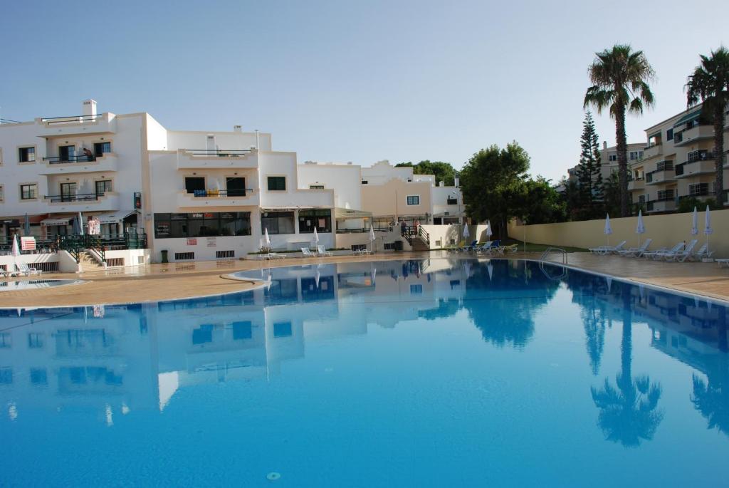 Una gran piscina azul frente a unos edificios. en Terraço e Mar, en Alvor