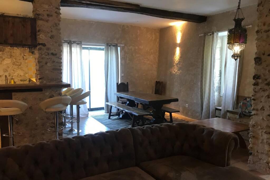 a living room with a couch and a table at MAISON RESTAUREE 6 PERSONNES AU COEUR DU PERIGORD in Sourzac