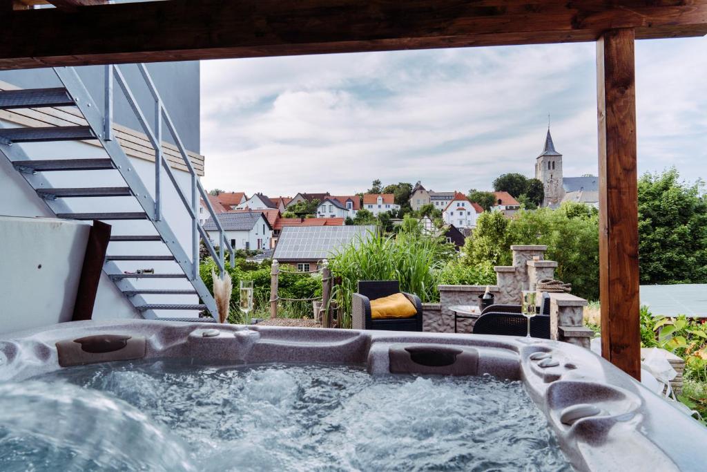 a hot tub on a balcony with a view of a city at Das Appartement in Marsberg
