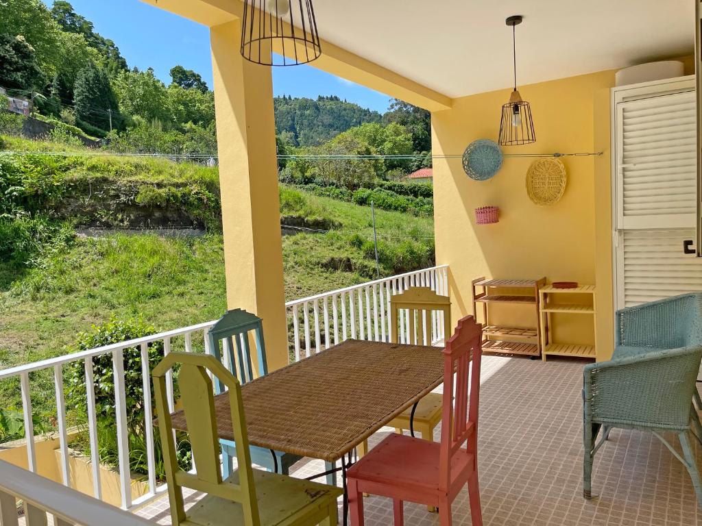 a porch with a table and chairs and a view at Thermal River Apartment in Furnas