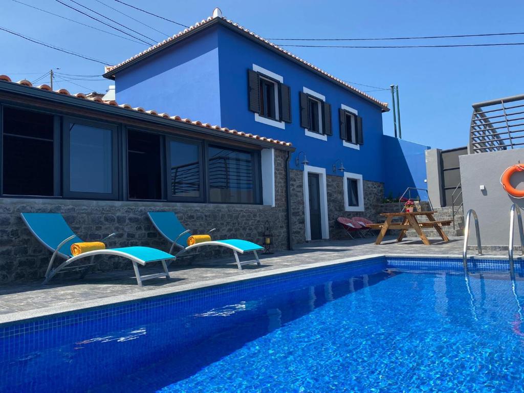 a villa with a swimming pool in front of a house at Casa da Morena in Santa Cruz