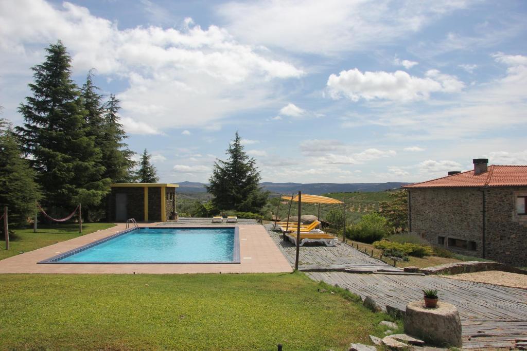 una piscina en un patio con una casa en Quinta Do Salgueiro B&B - Turismo Rural en Freixo de Espada à Cinta