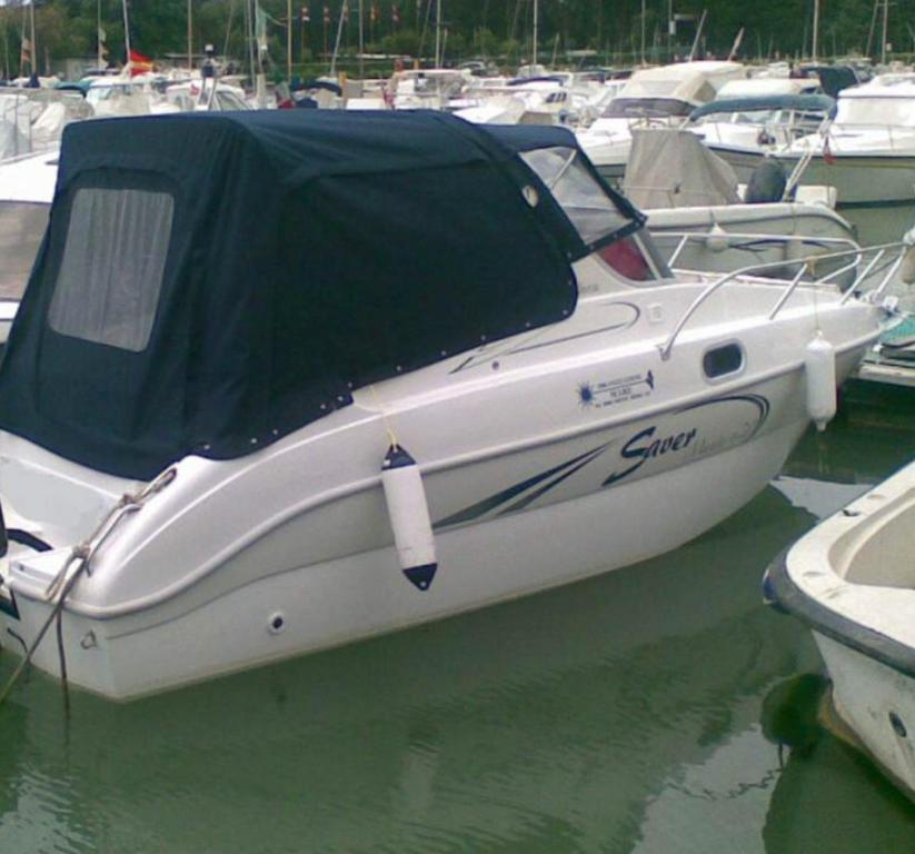 a white boat with a cover on the water at Bateau Love -Village Naturiste in Cap d'Agde
