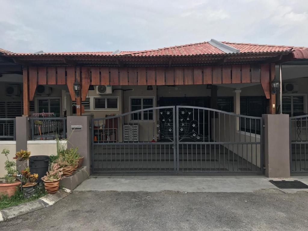 ein Haus mit einem Tor und einer Veranda in der Unterkunft No 96 Nazirin Homestay Lumut in Lumut