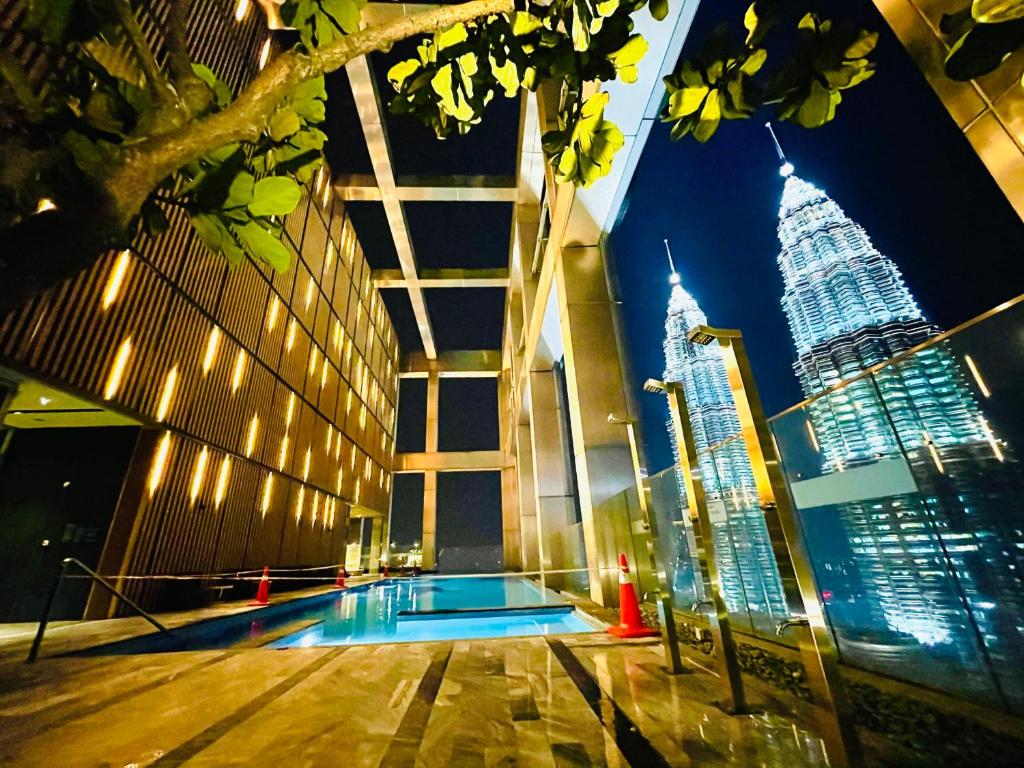 een zwembad in een gebouw met uitzicht op de stad bij Tropicana The Residences KLCC CozeeStay in Kuala Lumpur