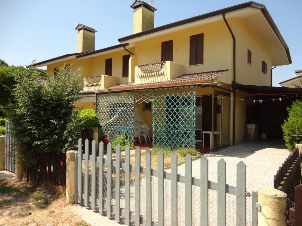 una recinzione bianca di fronte a una casa di Comfort and beauty in our precious villa for 6 a Porto Santa Margherita di Caorle