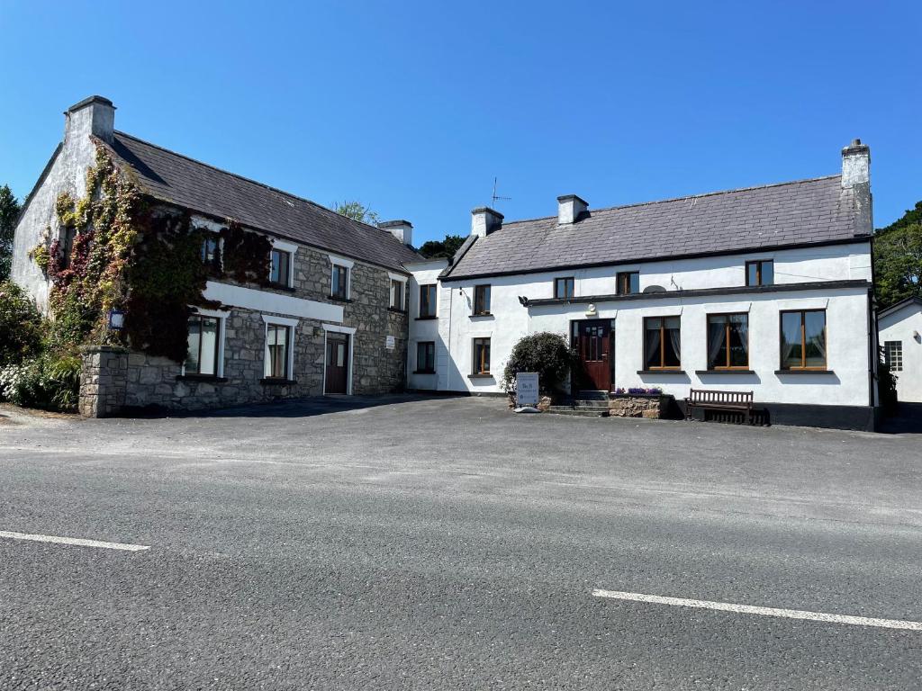 a couple of white buildings on the side of a street at O'Domhnaill's Guesthouse - Lig do Scíth in Galway