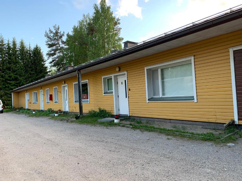 une rangée de petites maisons jaunes avec une allée dans l'établissement Laatokan Portti Apartments, à Parikkala
