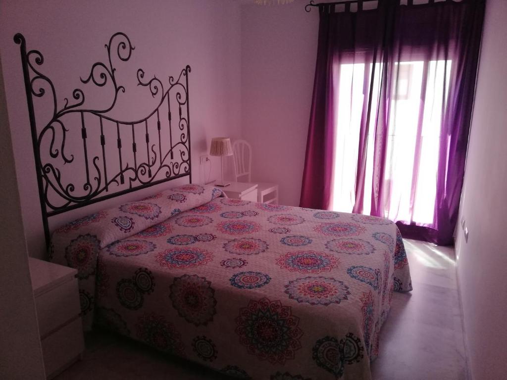 サンルーカル・デ・バラメダにあるEdificio Bolsa Centro 127のベッドルーム1室(花柄のベッドカバー付)