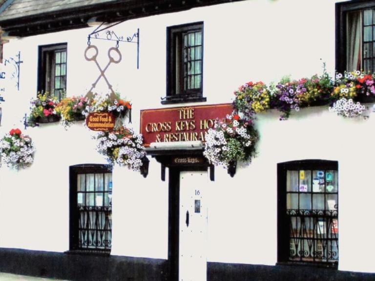 a white building with a sign in front of it at Cross Keys Hotel Chatteris in Chatteris