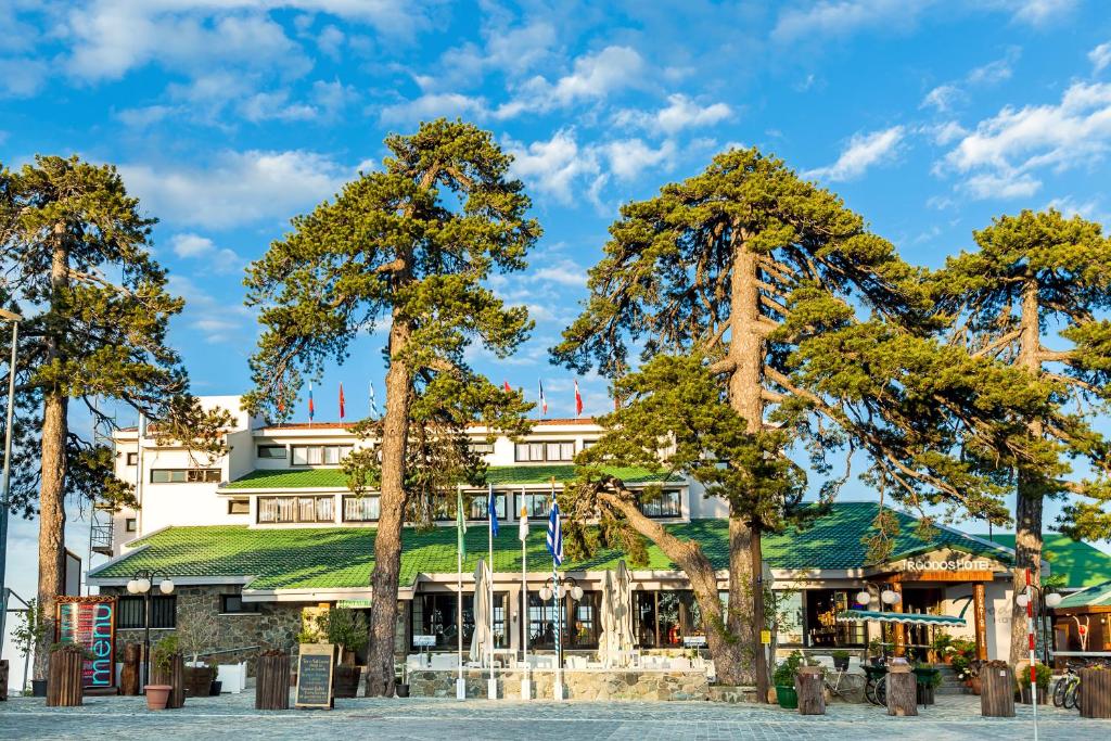 um grupo de árvores em frente a um edifício em Troodos Hotel em Troodos