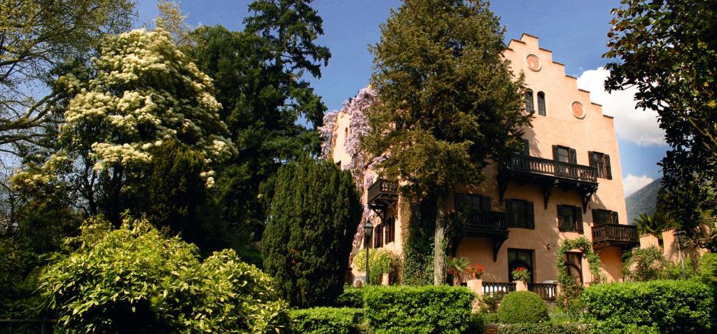 メラーノにあるSchloss-Castel Pienzenau - Guestrooms & Apartments - B&B-Hotel & Restaurantの目の前に木々が生い茂る大きな建物