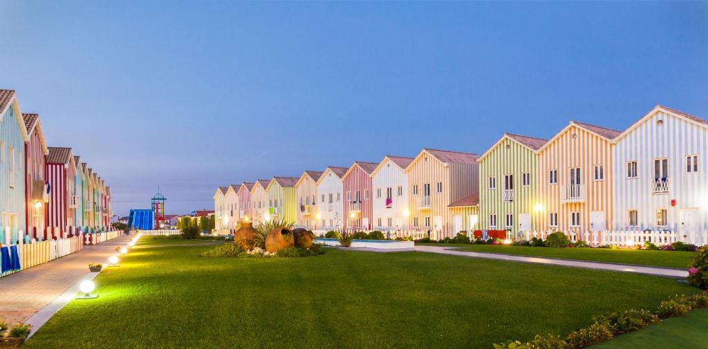une rangée de maisons avec une pelouse devant elles dans l'établissement Hotel Cristal Praia Resort & SPA, à Praia da Vieira