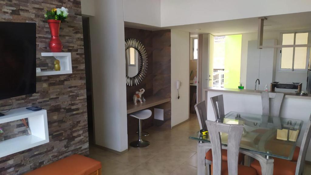 cocina y comedor con mesa de cristal y sillas en Excelente apartamento en villeta cundinamarca, en Villeta