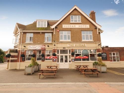 a hotel with picnic tables in front of a building at Hussar Inn in Margate