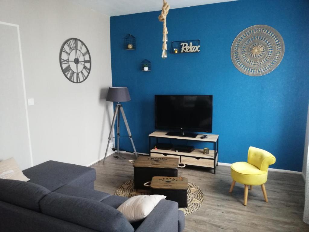 een blauwe woonkamer met een bank en een tv bij appartement avec 2 chambres, proche de la gare de saint brieuc in Saint-Brieuc