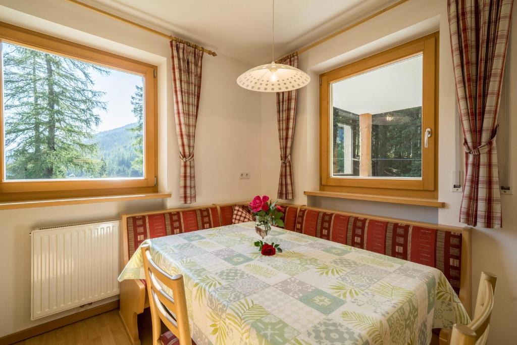 フェルダーズにあるFerienhaus Maria Arnikaのテーブルと2つの窓があるダイニングルーム