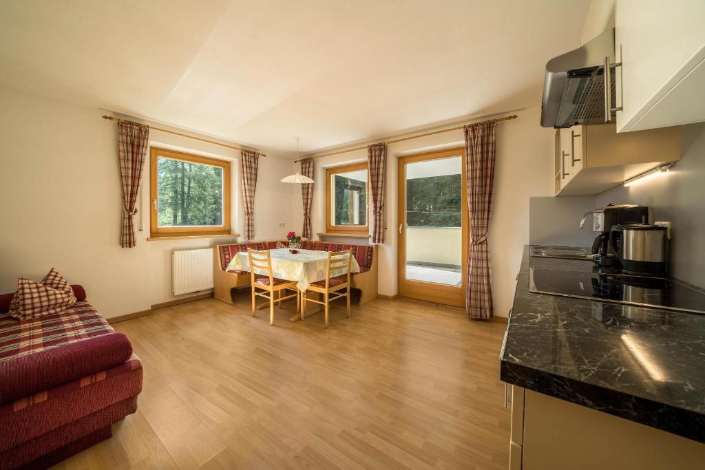 eine Küche und ein Wohnzimmer mit einem Tisch in der Unterkunft Ferienhaus Maria Arnika in Pfelders