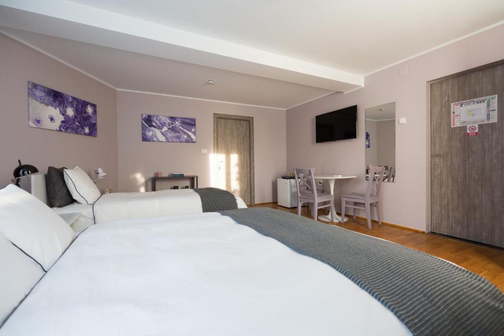 a hotel room with a large white bed and a table at Casa Ris in Târgu Jiu