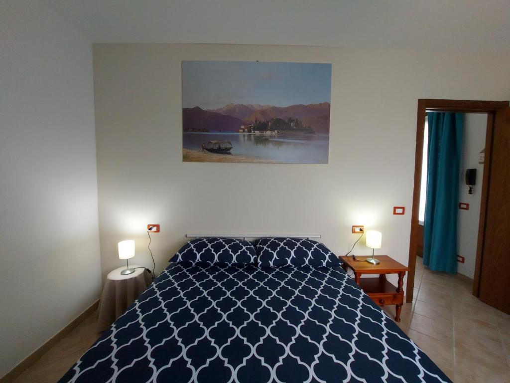 una camera con un letto blu e due lampade di La Casa delle Camelie a Stresa