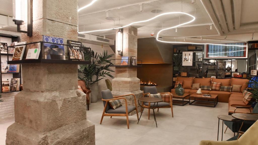 un hall d'un magasin avec des chaises et des tables dans l'établissement LATROUPE La Granja, à Bilbao