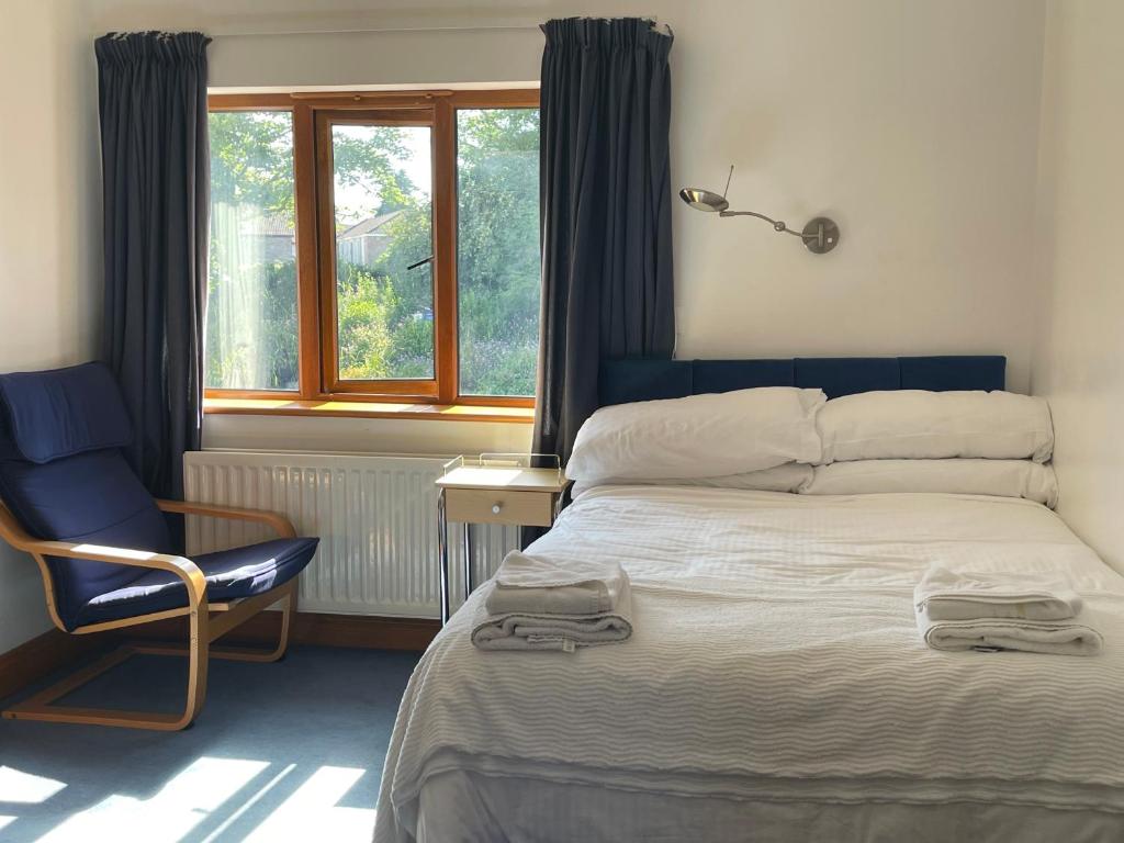 una camera da letto con un letto, una sedia e una finestra di O'Domhnaill's Guesthouse - Lig do Scíth a Galway