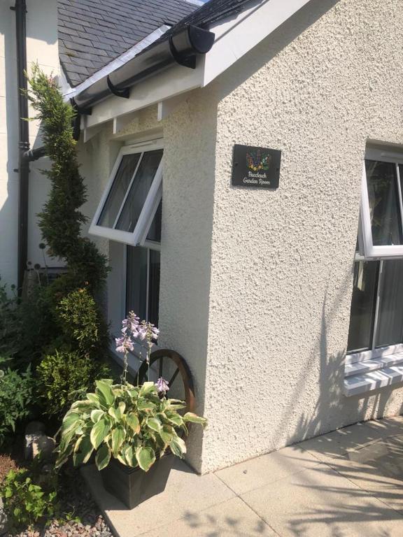 a house with a sign on the side of it at Buccleuch Garden Room in Fort William