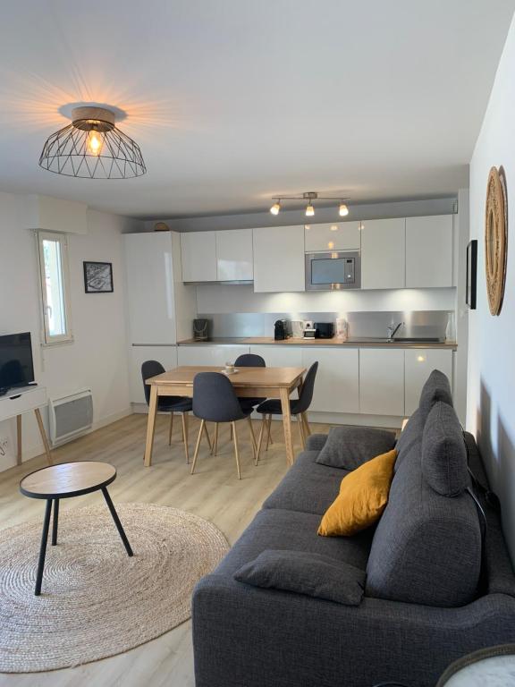 un soggiorno con un divano e un tavolo di Appartement cosy plein centre à 2 pas de la plage a Le Touquet-Paris-Plage