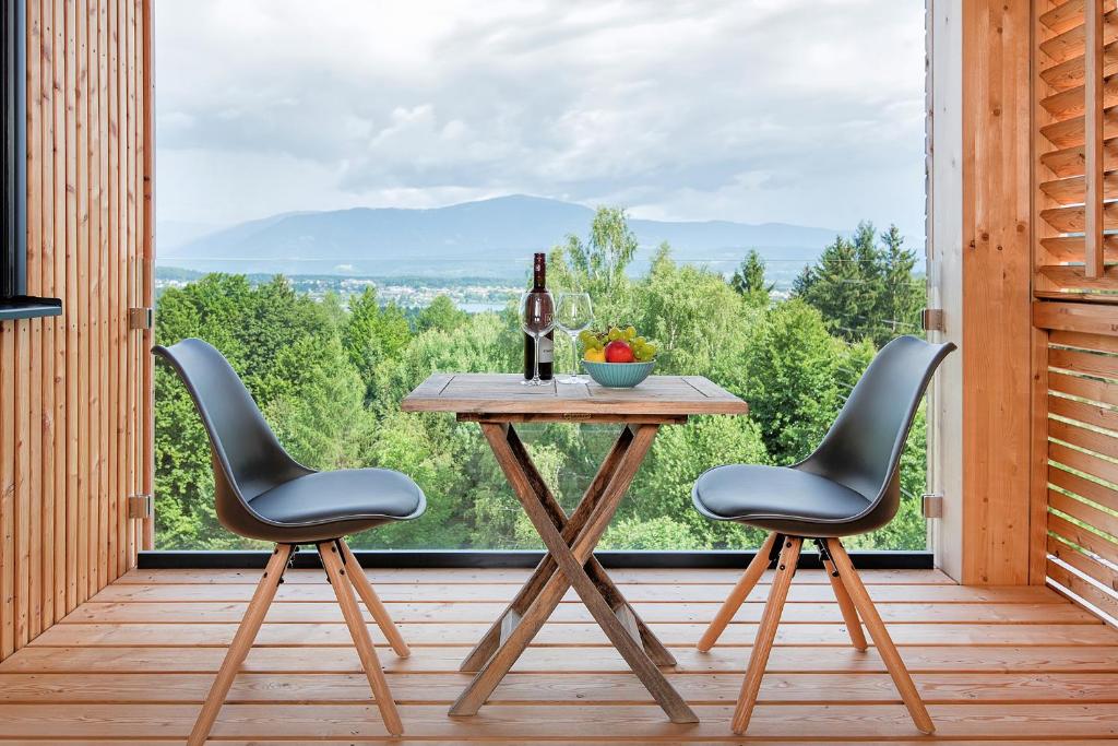un tavolo con due sedie e una bottiglia di vino sul portico di Haus Deutz a Oberaichwald