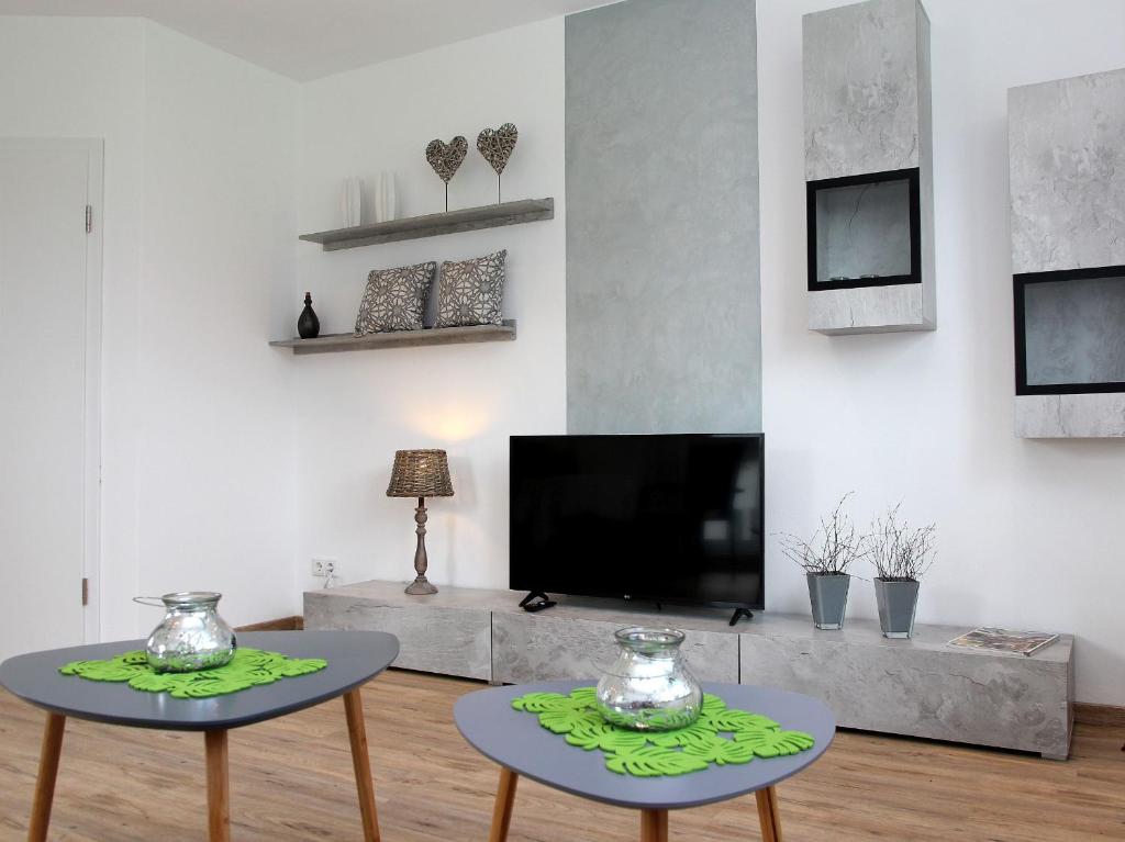 two tables in a living room with a tv at Ferienwohnung Darge in Schmallenberg