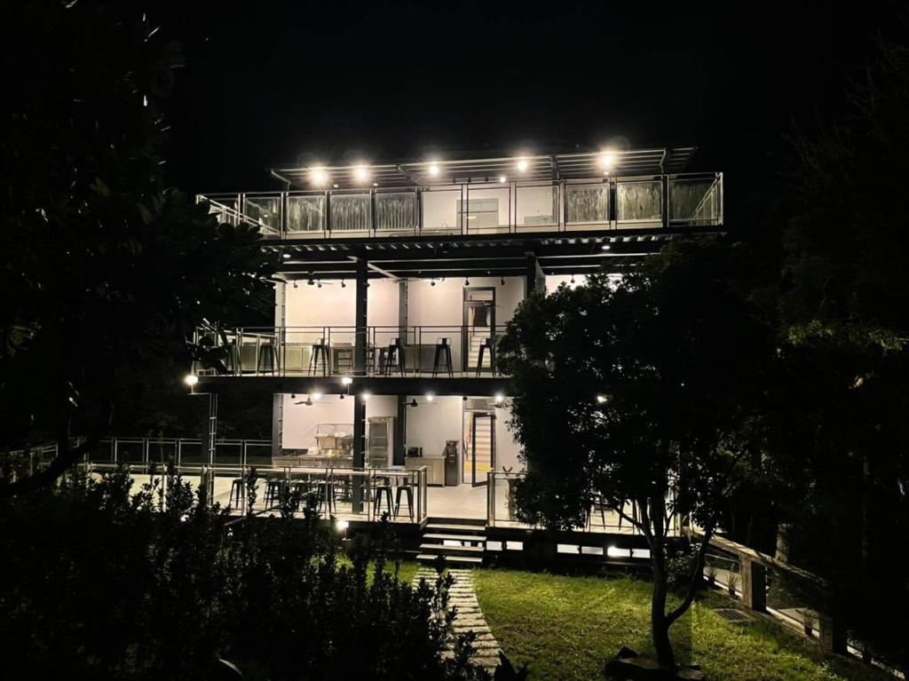 un bâtiment avec une terrasse éclairée la nuit dans l'établissement Sla Ulay Backpacker Hostel, à Wulai