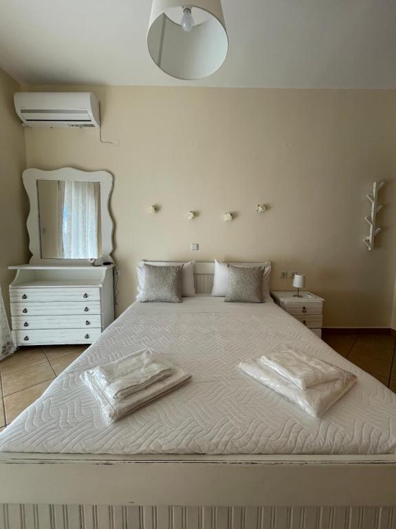 een slaapkamer met een wit bed en 2 handdoeken bij Ouranias Guesthouse in Chania