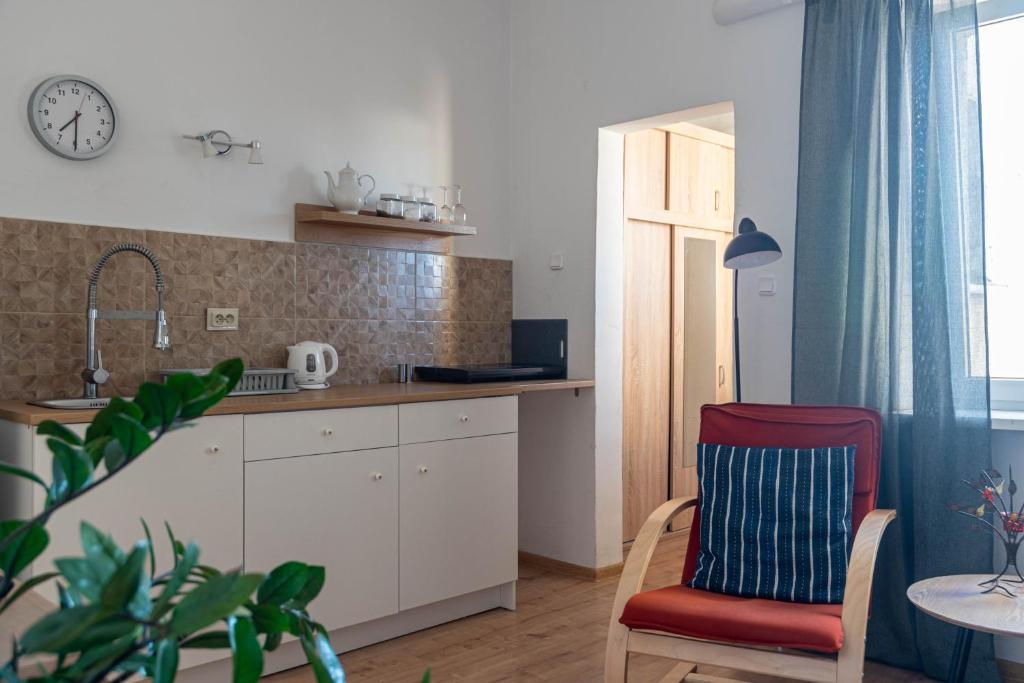 a kitchen with a red chair and a table at Studio Kościuszki in Łódź