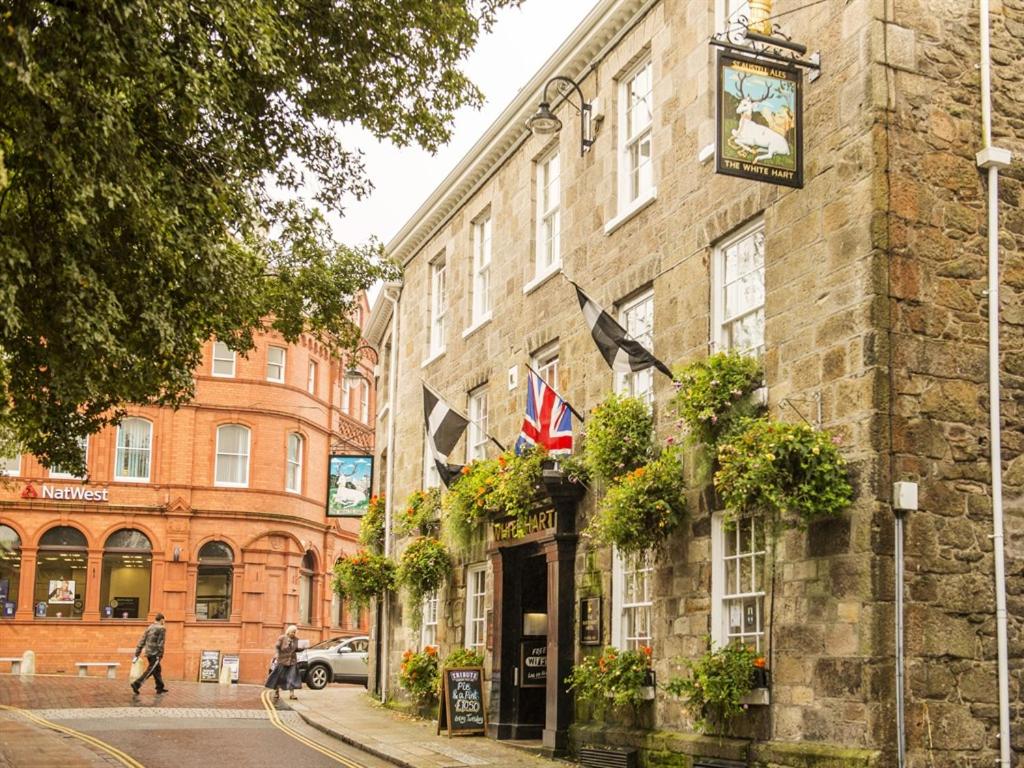 a building with a clock on it on a street at White Hart Hotel in St Austell