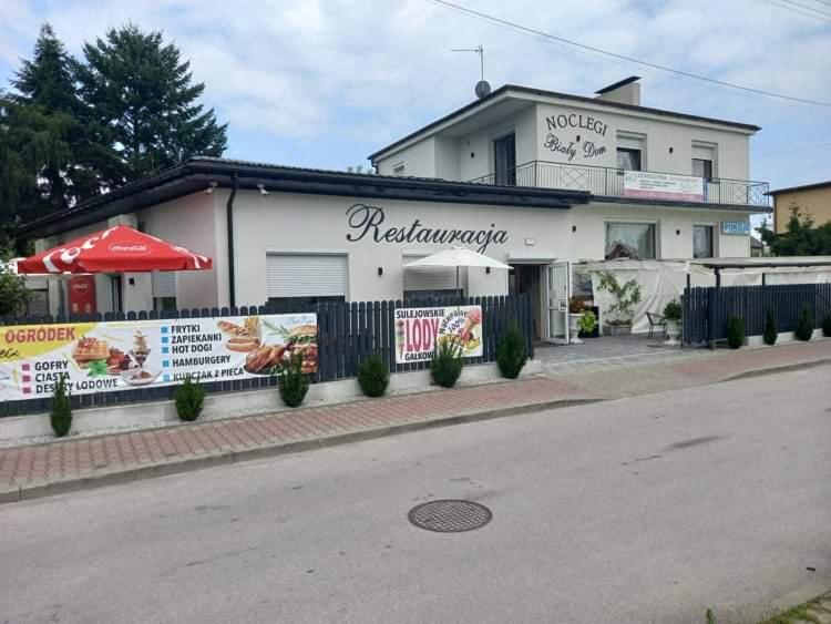 a restaurant with a sign on the side of the building at Bialy Dom in Sulejów