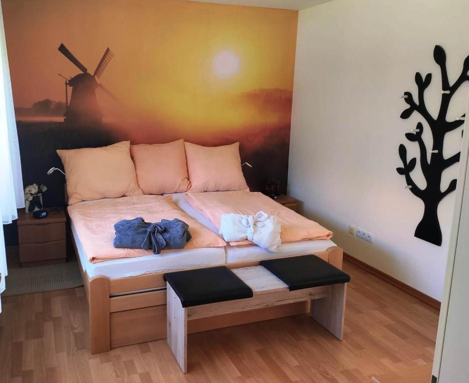 1 dormitorio con 1 cama y una pintura de un molino de viento en Ferienhaus Emden Zur Mühle Nordseeküste, en Emden