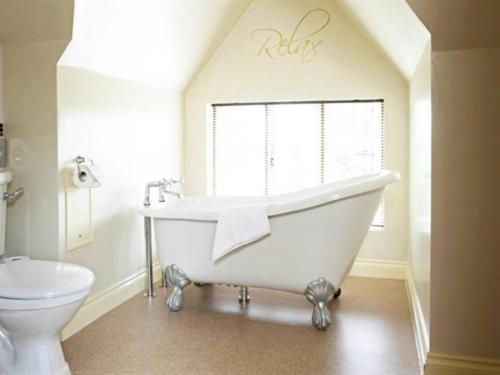 a bathroom with a white tub and a toilet at Broom Hall Inn in Stratford-upon-Avon